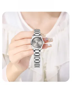 Close-up of a silver steel strap watch featuring a minimalist round dial on a wrist
