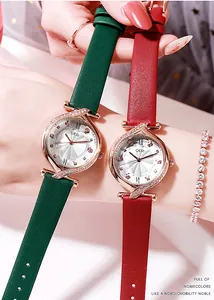 Primo piano di orologi al quarzo di lusso con strass e cinturini in pelle verde e rosso vino