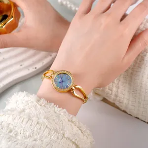 Montre bracelet élégante pour femme en or avec cadran nacre bleue et lunette en cristal