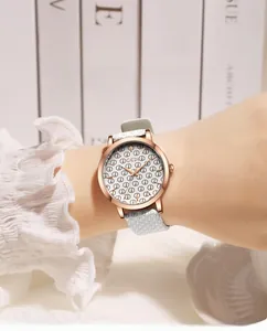 Detail of rose gold quartz watch with GD logo dial and light blue leather strap