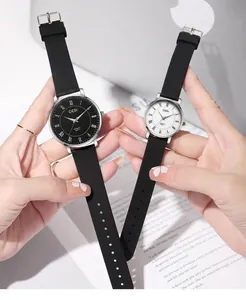 Close-up of elegant black and white couple watches with Roman numerals and silicone bands