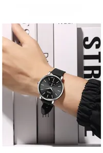 Detailed close-up of a minimalist quartz watch with black sunburst dial and silicone strap