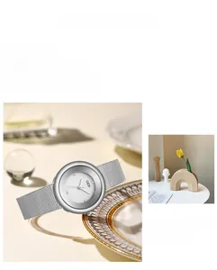 Detail of silver mesh band watch with retro dial and diamond markers on metal tray