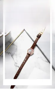 Close-up of GEDI rose gold quartz watch with diamond bezel and brown leather strap