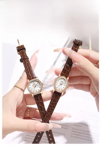Close-up of luxury women's watch with brown leather strap and diamond-encrusted bezel