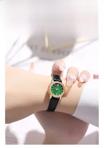 Close-up of green dial watch with rose gold diamond bezel on female wrist