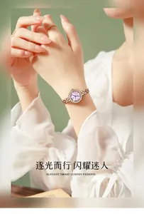 Detail of rose gold rhinestone bezel watch with chain strap worn on wrist