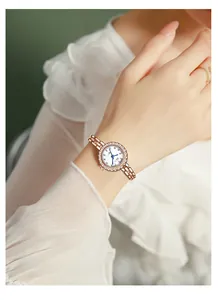 Close-up of GEDI rose gold watch with rhinestone bezel and elegant chain strap on wrist