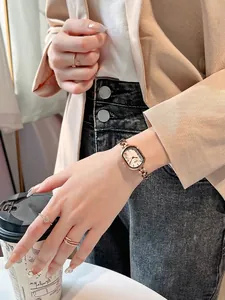 Close-up of rose gold oval watch with mother-of-pearl dial on a woman's wrist