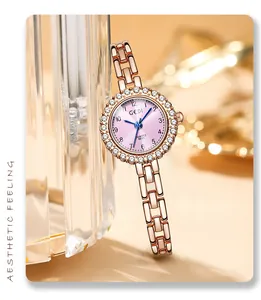 Detail of rose gold diamond-set watch with pink dial and blue hands against champagne background