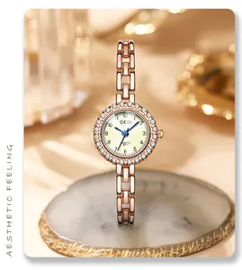 Detailed close-up of GEDI rose gold watch with rhinestone bezel on marble stand