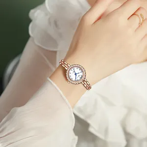 Women's rose gold quartz watch with diamond bezel and blue hands on white dial