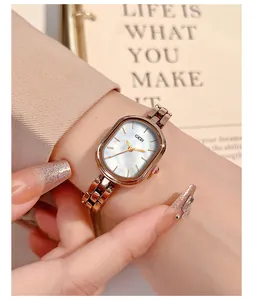 Detail of rose gold quartz watch with oval mother of pearl dial on woman's wrist