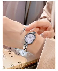 Detail view of a refined silver link watch with a purple mother-of-pearl dial for women