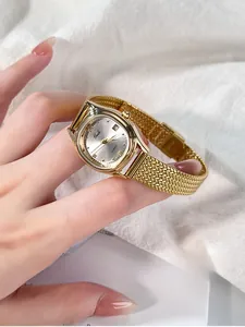 Close-up of golden tonneau quartz watch with mesh strap and date display on female wrist