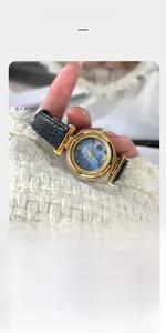 Close-up of a women's quartz watch with blue mother of pearl dial and black leather strap