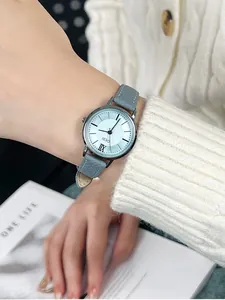 Detailed shot of GEDI women's watch with grey leather strap and light blue dial on wrist