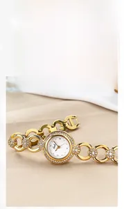 Dettaglio di un orologio a bracciale dorato di lusso con lunetta di cristalli e quadrante tondo
