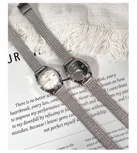 Close-up of silver mesh strap quartz watches with black and white dials for women