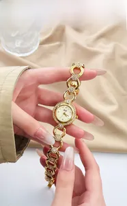 Dettaglio dell'orologio al quarzo dorato con lunetta in cristallo e cinturino a catena
