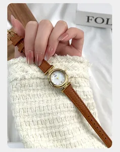 Close-up of mother of pearl dial and brown lychee leather strap on a gold watch