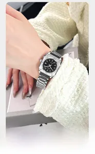 Close-up of a silver stainless steel square watch with a black dial and screw details