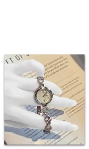 Detail of GEDI watch showing heart rhinestones and mother of pearl dial on white background