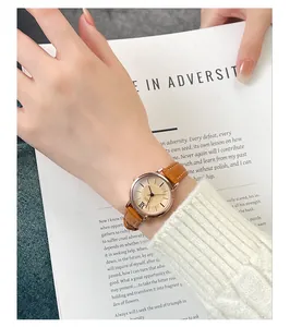 Detailed view of women's vintage quartz watch with brown leather strap on a magazine