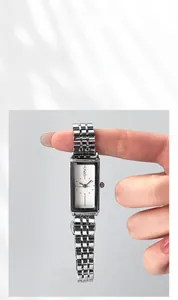Detail shot of the rectangular silver steel watch band and the polished quartz dial case