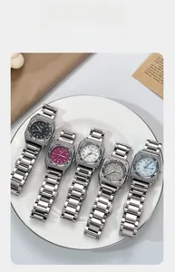 Flat lay of square quartz watches with five colorful dials on a ceramic plate