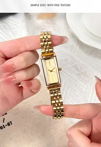 Detailed shot of retro gold rectangular watch with stainless steel strap on wrist