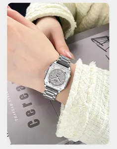 Detailed view of silver square quartz watch with steel band and date display on a wrist