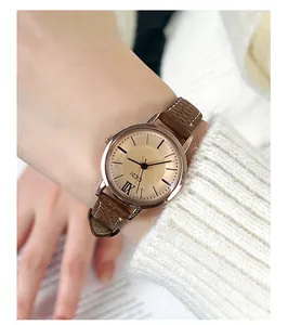 Detailed macro view of the vintage gold dial and brown leather strap on women quartz watch