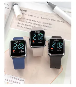 Three digital sports watches with silicone straps shown on an open book in a study setting