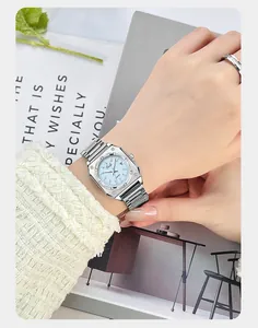 Close-up of elegant square blue dial watch with silver steel strap on woman wrist