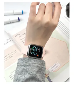 Close-up of pink silicone strap digital sports watch on wrist with silver square case