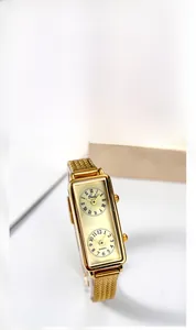 Détail de la montre à double cadran doré avec chiffres romains et bracelet en maille