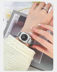 Detail of silver octagonal bezel watch with black dial and date display on a wrist