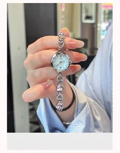 Close-up of a silver watch with pink heart-shaped crystals and镂空 bracelet links