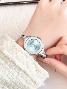 Close-up of elegant silver bangle watch with light blue sunray dial and crystal accents