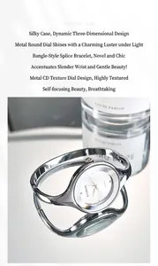 Close-up of a silver bangle watch featuring a white round dial and quartz movement detail