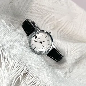 GEDI minimalist quartz watch with silver round case and black leather strap on white fabric
