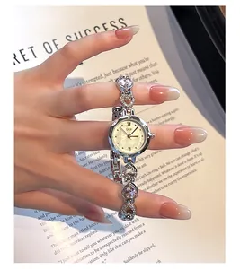 Close-up of women's silver bracelet watch with heart-shaped crystal links and pearl dial