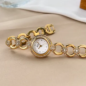 Orologio a bracciale Gedi dorato elegante con strass su sfondo di tessuto strutturato