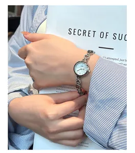 Detail view of an elegant silver heart-shaped bracelet watch worn on a female wrist.