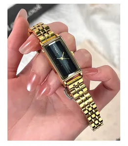 Close-up of a vintage rectangular gold steel watch with a sleek black dial and mesh band
