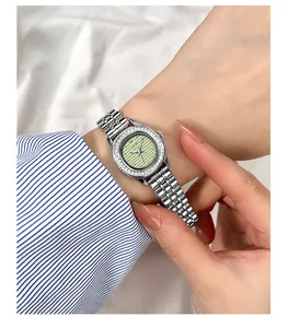 Détail d'une montre à quartz argentée GEDI avec cadran vert et lunette sertie de diamants