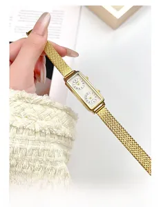 Gros plan d'une montre rectangulaire dorée à double cadran avec bracelet en maille métal