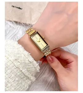 Close-up of a vintage rectangular gold stainless steel watch worn on a wrist