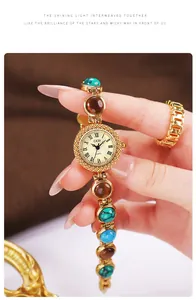 Gros plan d'une montre bracelet GEDI dorée ornée de pierres œil-de-chat colorées